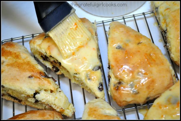 Orange glaze is brushed on top of chocolate chip orange scones