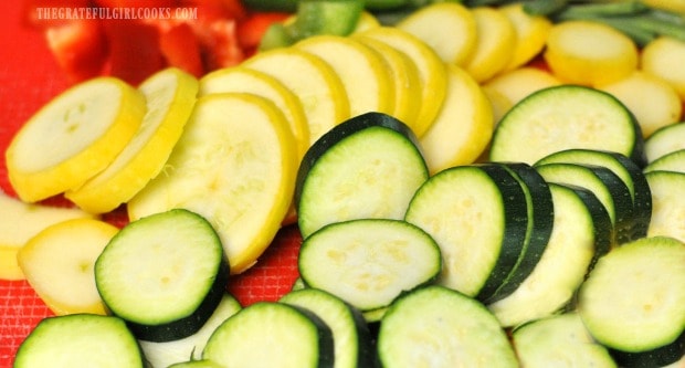 Zucchini squash and bell peppers, sliced for honey lime chicken skewers.