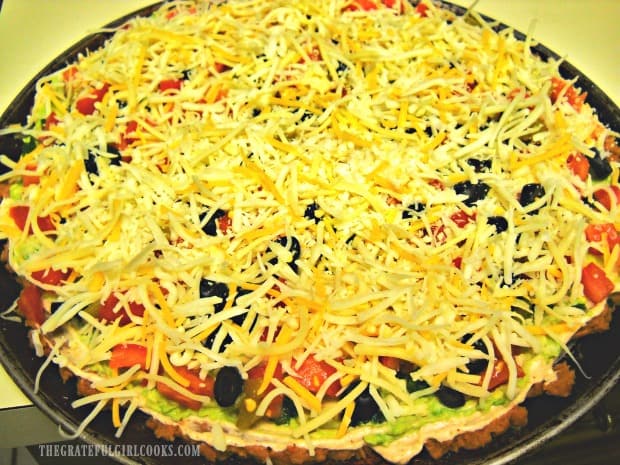 A pizza platter filled with the Mexican layer dip, ready to eat!