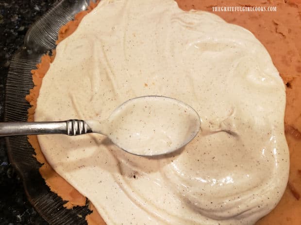 The spicy sour cream mixture is spread over the top of the refried bean layer.