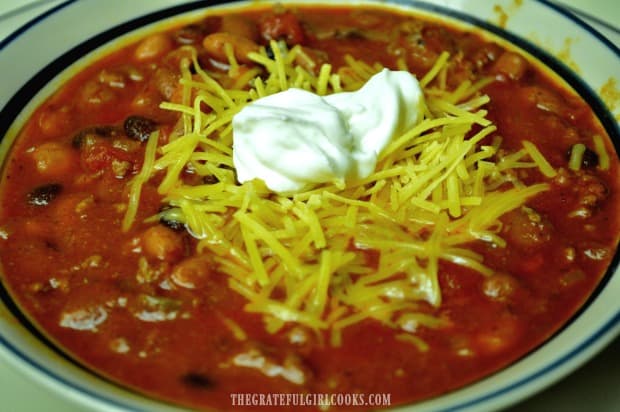 A bowl of Mom's old-fashioned chili, topped with sour cream and grated cheddar cheese.