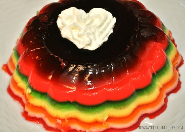 Rainbow jello salad with a whipped cream garnish is ready to eat!