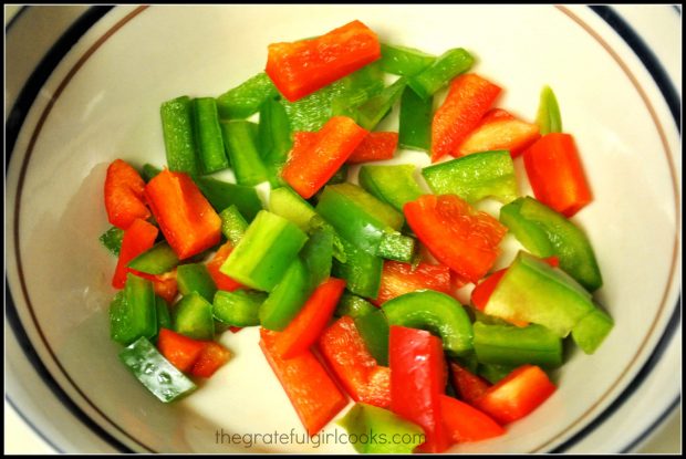 Red and green bell peppers are chopped for Hawaiian meatballs and rice.