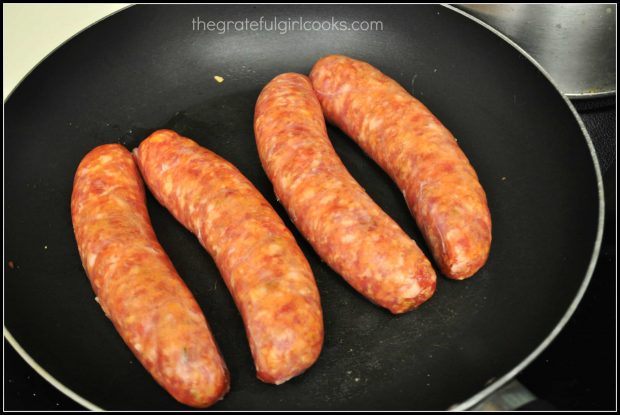 Italian sausage links are pan-seared in skillet.