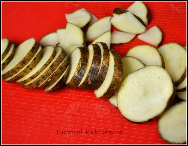 Unpeeled russet potatoes are cut into thin slices, then cut into quarters.