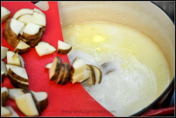 Potatoes being added to the Olive Garden Toscana Soup in pan.