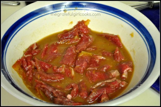 Steak marinates in orange and soy sauce before cooking.