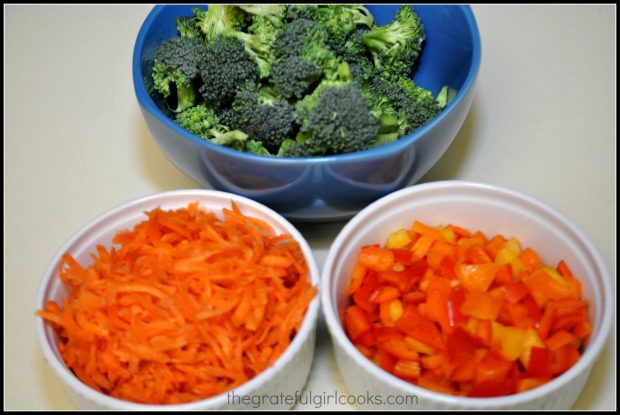 Broccoli, bell peppers and carrots are chopped and prepped before stir frying.