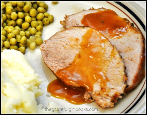 Mashed potatoes and peas are served with orange glazed pork roast.