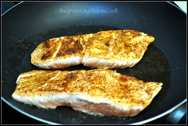 Pan seared creole salmon cooking in skillet.