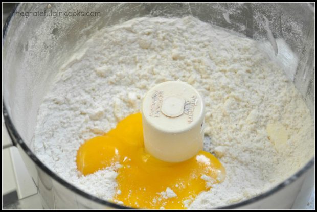 Egg yolks are added while preparing tart in a food processor.