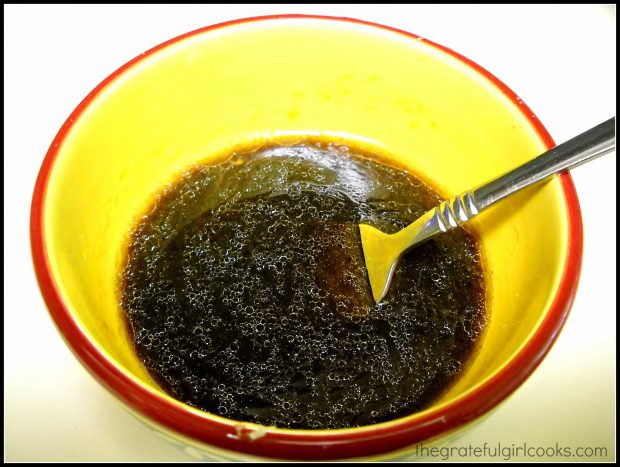 Salad dressing for salad is mixed in yellow bowl.