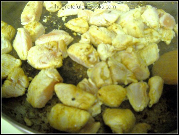 Chunks of chicken breast are cooked until golden brown.