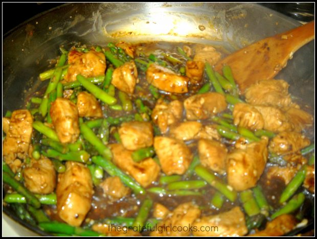 Asparagus is added to the lemon sauce and chicken in skillet to finish cooking.