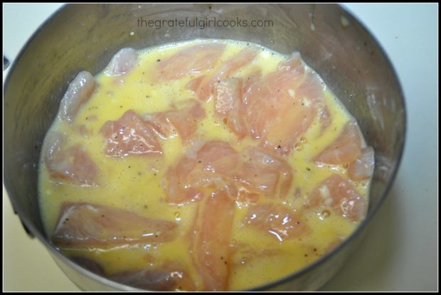 Chicken breast slices for P.F. Chang's ginger chicken, marinading in metal bowl