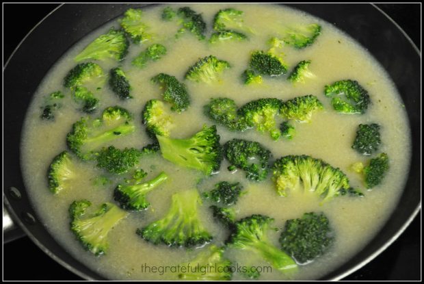 Broccoli florets for P.F. chang's ginger chicken with broccoli are cooking in broth.