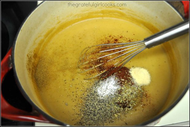 Mexican spices are added to mole sauce in large pan, for burritos.