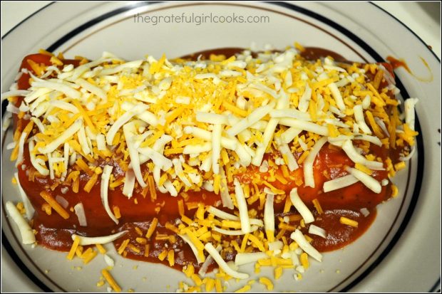Shredded Pork Smothered Burrito is covered with red sauce, then grated cheddar and jack cheese before heating.