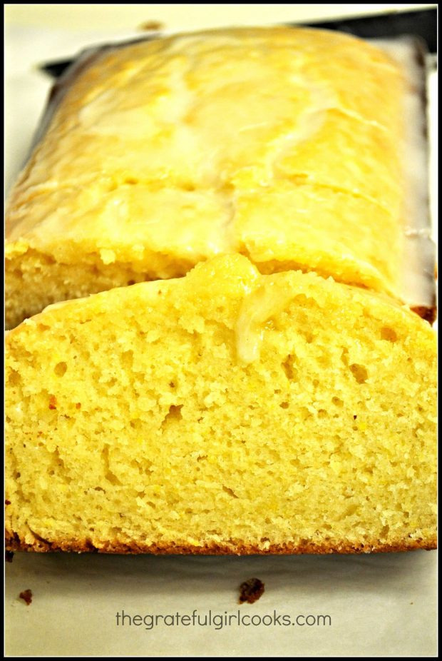 A slice of Starbucks lemon loaf (copycat version), with the rest of the loaf behind it.