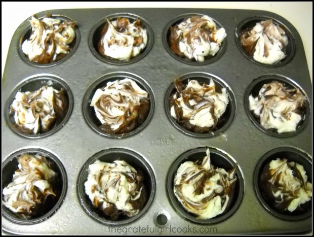 Cheesecake filling is swirled into the brownie batter in the muffin cups.