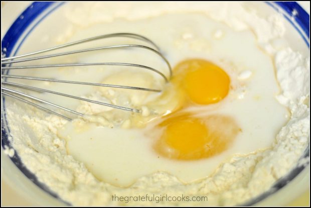 Eggs are whisked into onion ring batter.