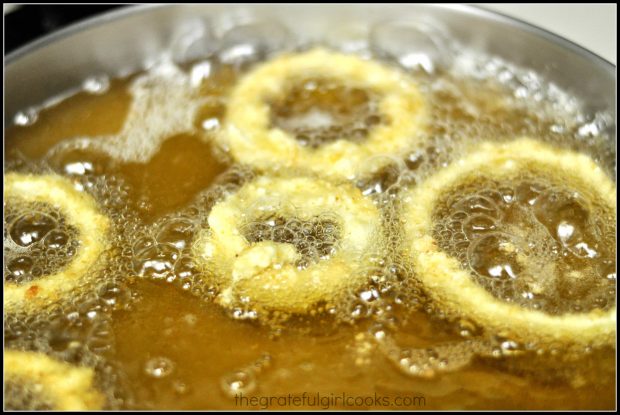 Battered onion rings are fried in hot oil