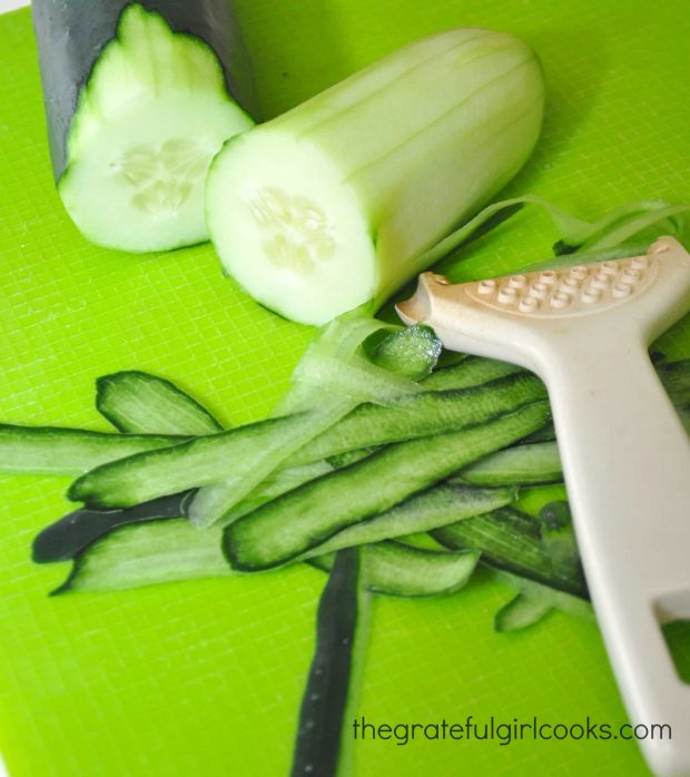Cucumbers are peeled to use in the Greek salad.