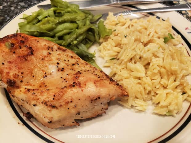 Baked chicken is served with green beans and orzo with Parmesan on the side.