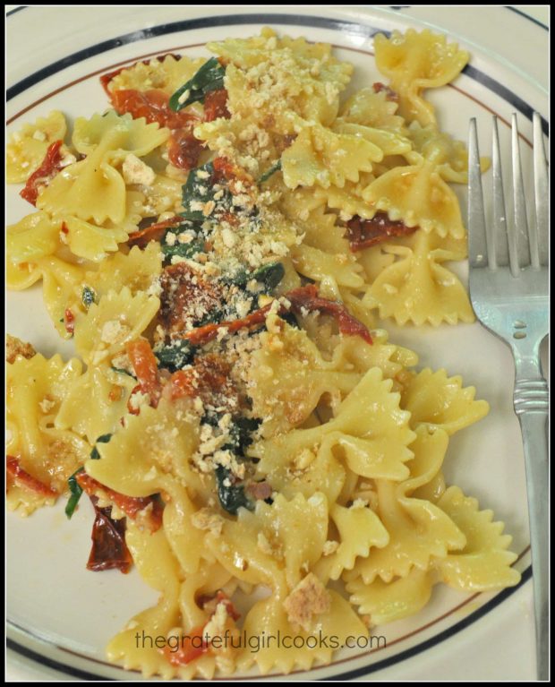 Farfalle Pasta with Arugula and Sun-Dried Tomatoes, on a plate, and ready to eat.