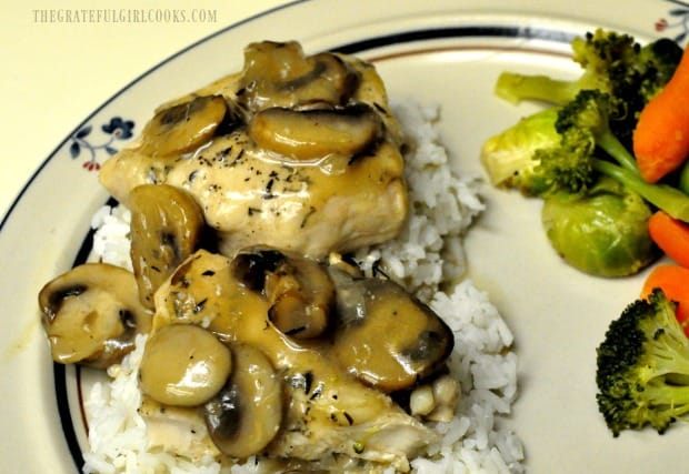 Chicken Marsala is served on a bed of rice, with mixed vegetables on the side.