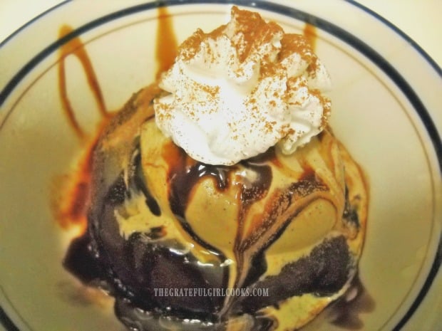 Coffee ice cream on top of molten lava cake with syrup and whipped cream