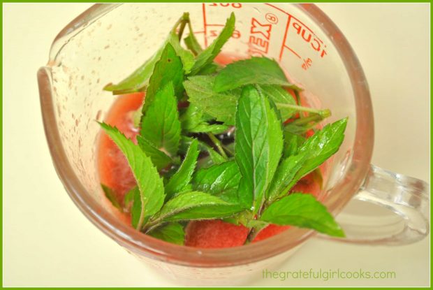 Fresh mint leaves are added to a small amount of watermelon puree