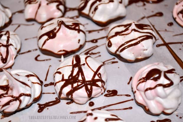 The raspberry chocolate meringues are drizzled with melted chocolate.