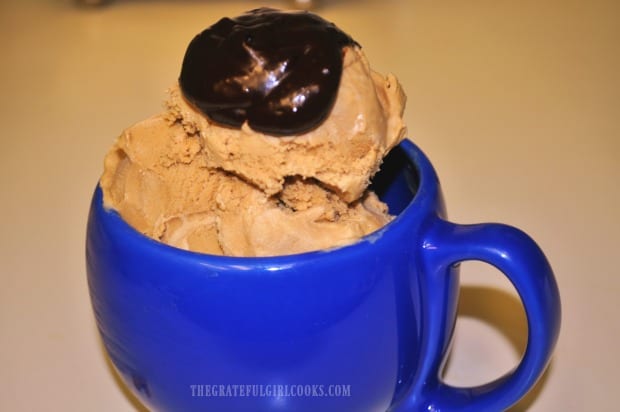Coffee ice cream with fudge topping, in a blue mug