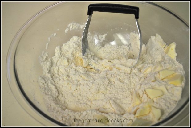 Butter is cut into dry ingredients for cinnamon chip scones, using a pastry blender
