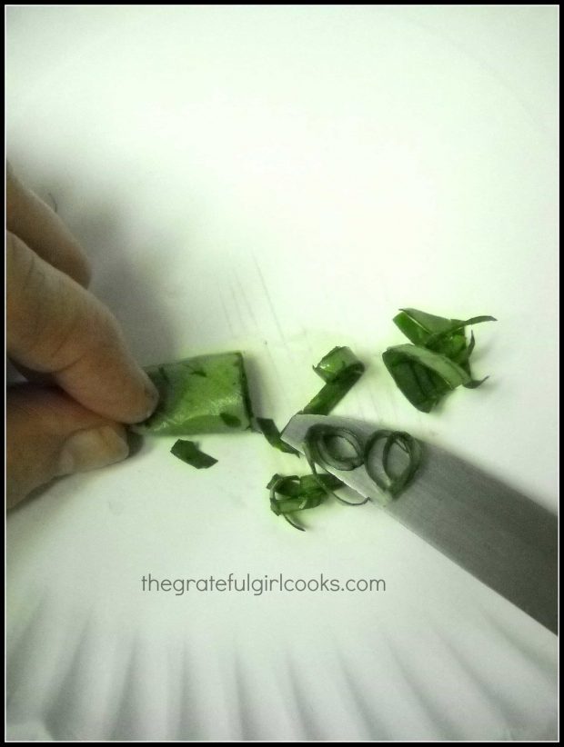 Basil is sliced into thin strips before adding to sandwich.
