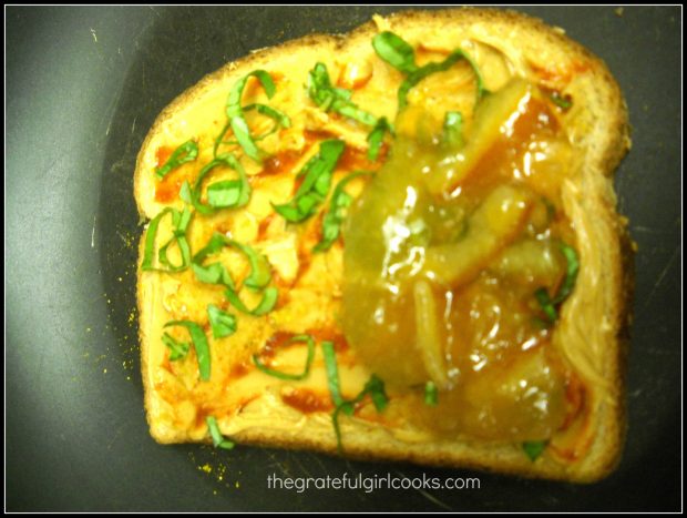 Sliced basil leaves and orange marmalade added to PB&J sandwich.