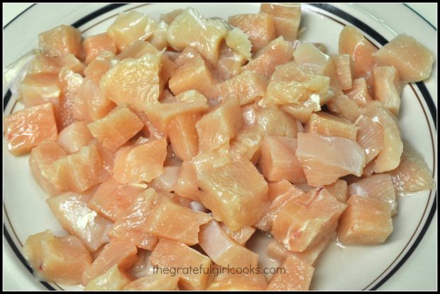 Chicken breasts are cut into cubes to use in making kung pao chicken.