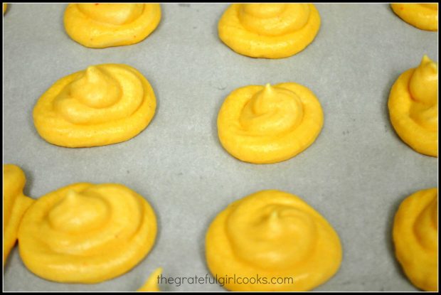 The orange meringue kisses are piped onto baking sheet and baked slowly.