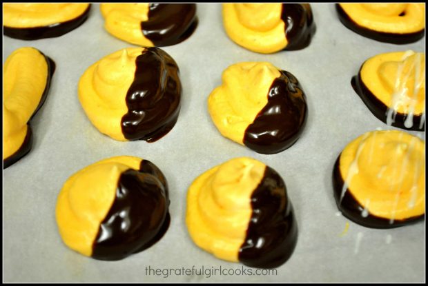 Orange meringue kisses are dipped in chocolate after baking.