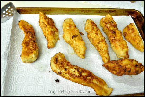Fried chicken pieces draining on paper towel