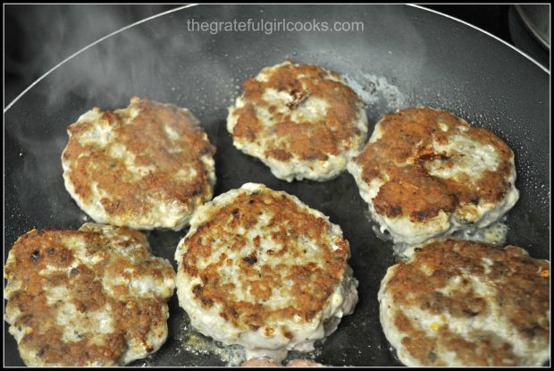 Browned homemade breakfast sausage patties cooking in skillet.