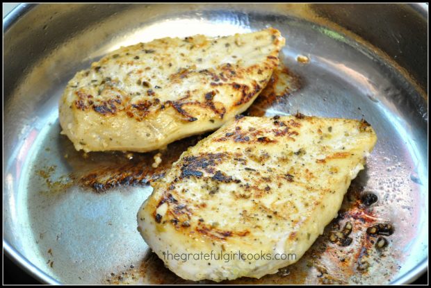 Two of the marinated, pan-seared Mexican chicken breasts cook in a skillet.