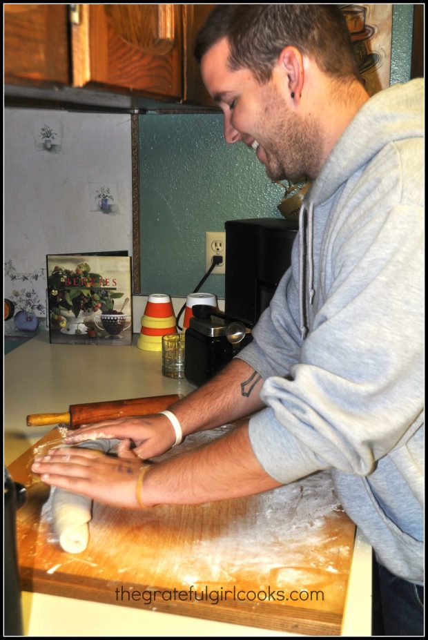 Rolling dough for miracle bread into a loaf shape.