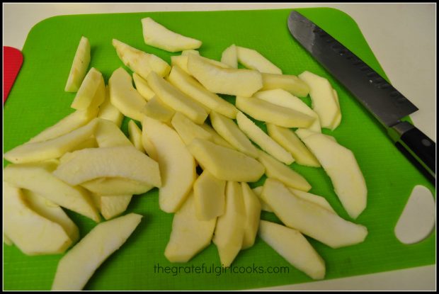 Golden delicious apples are peeled and sliced before cooking.