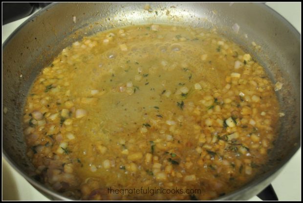 Shallots, thyme and wine are added to the sauce in the skillet.