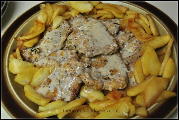 Apple cider sauce is poured over the cooked pork tenderloin with apples.