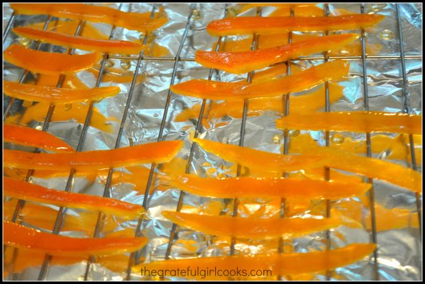Cooked candied citrus peels dry on a wire rack overnight.