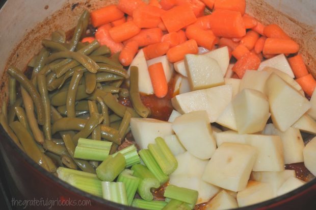 Carrots, potatoes, celery and green beans are added to classic beef stew, then baked.