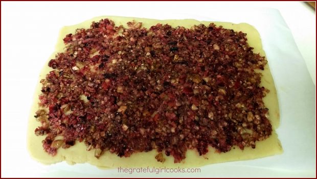 The dough for cranberry-orange pinwheel cookies is covered with cranberry pecan filling.